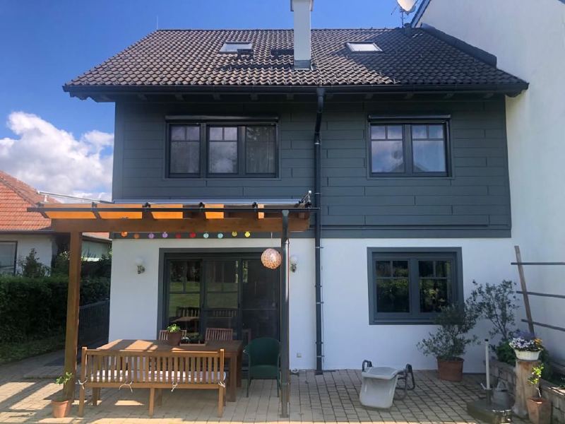 Gartenansicht des Hauses mit Siding-Obergeschoß