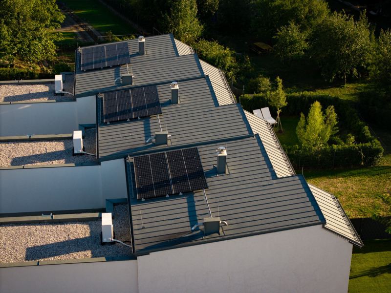 Versetzte Stehfalzdächer der Reihenhäuser mit Photovoltaik und Ortgangverblechung
