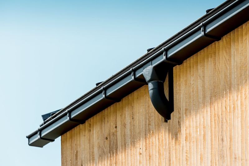 Dachrinne und Traufe an einem Haus mit Holzfassade